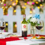 Romantic dinner scene with wine, flowers, and gourmet meal. Perfect for a cozy evening.